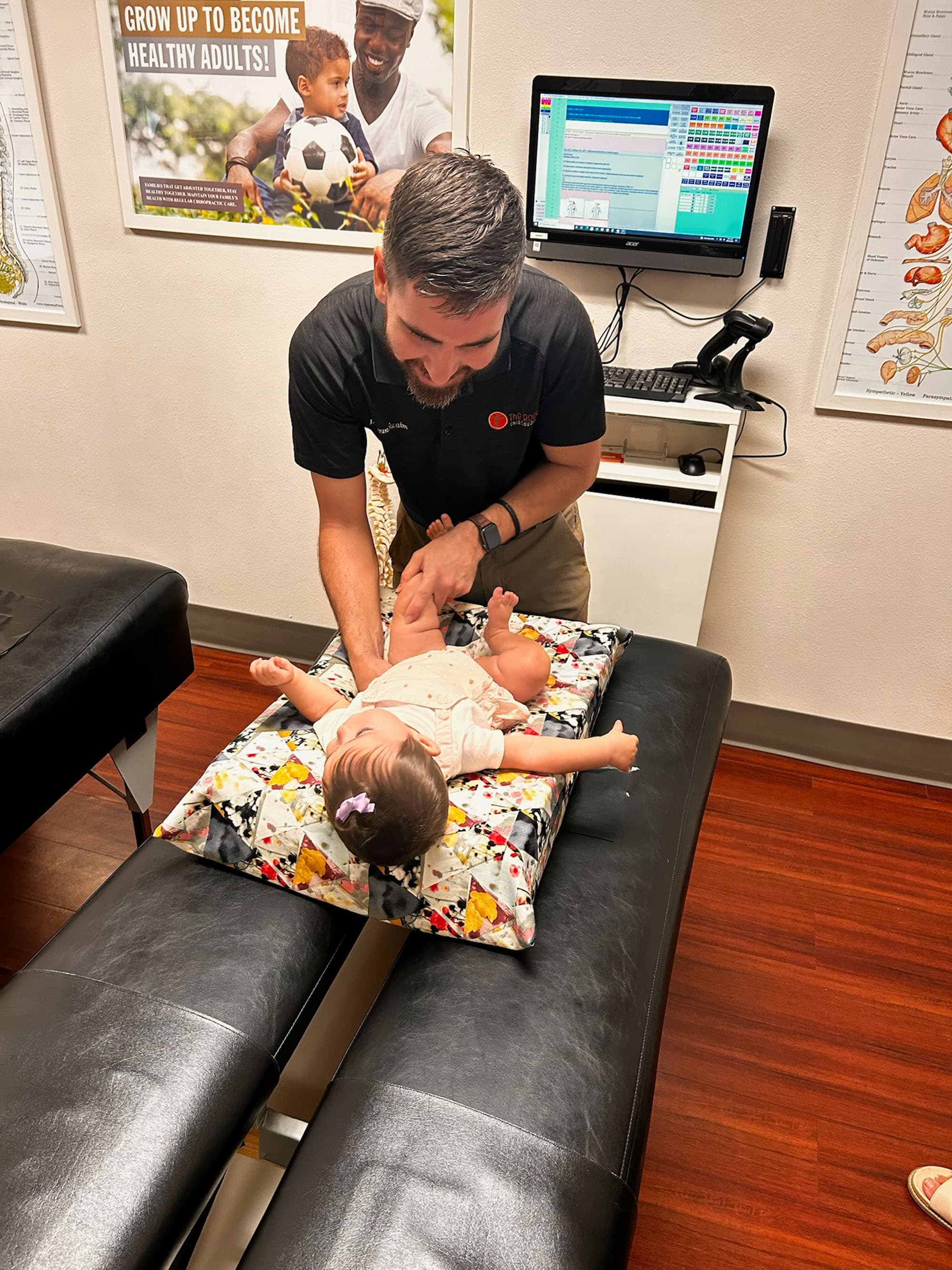 Dr. Grayson Fox gently works on an infant at Little Roots Pediatric Chiropractic.