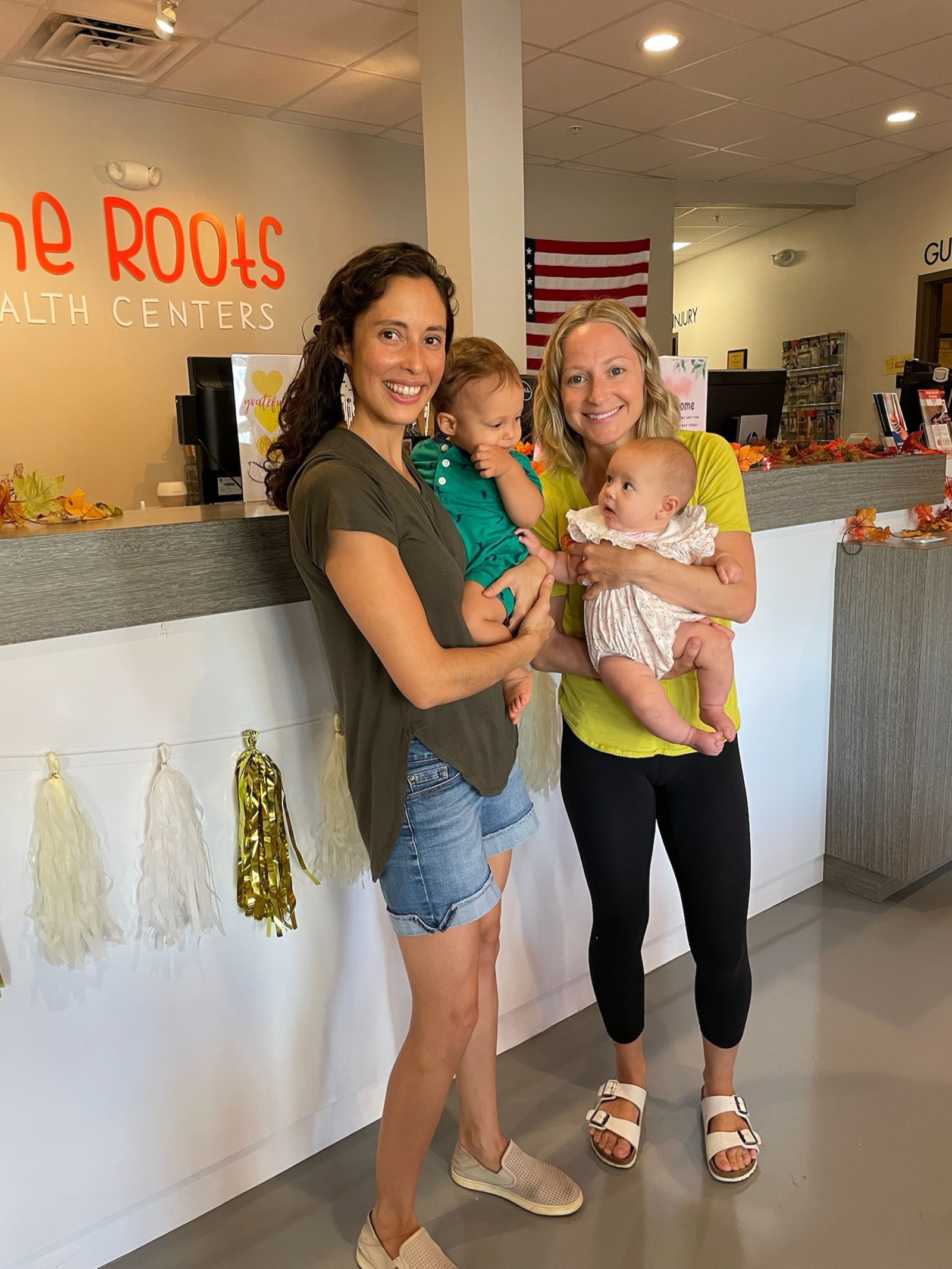 Dr. Laura with another mom holding infants at the clinic reception.