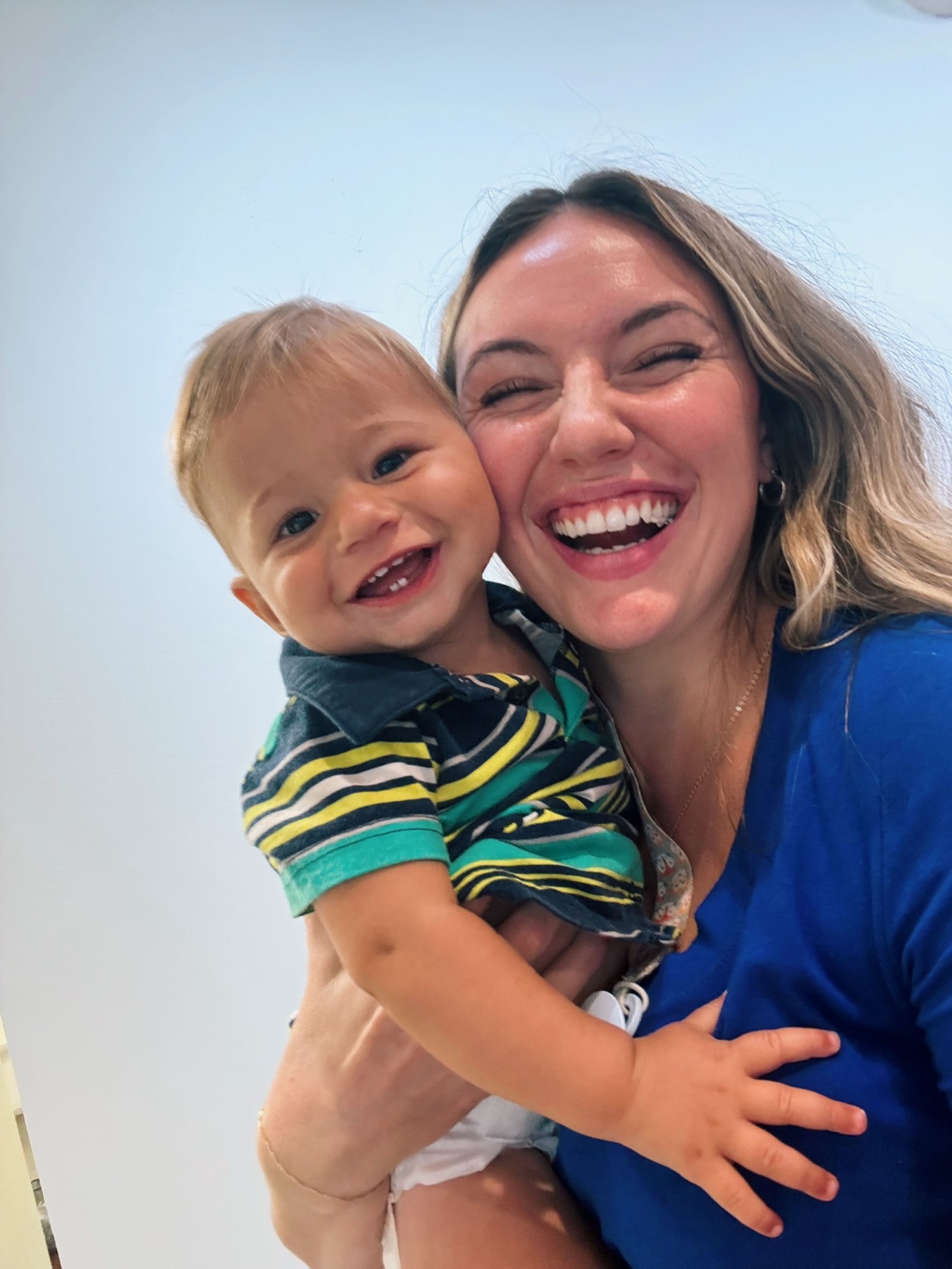 Carly laughs with a joyful toddler patient.